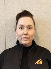 Siiri McDonagh henkilökuva_rajattu Kuva tuotantopäällikkö Siiri McDonaghista harmaalla taustalla